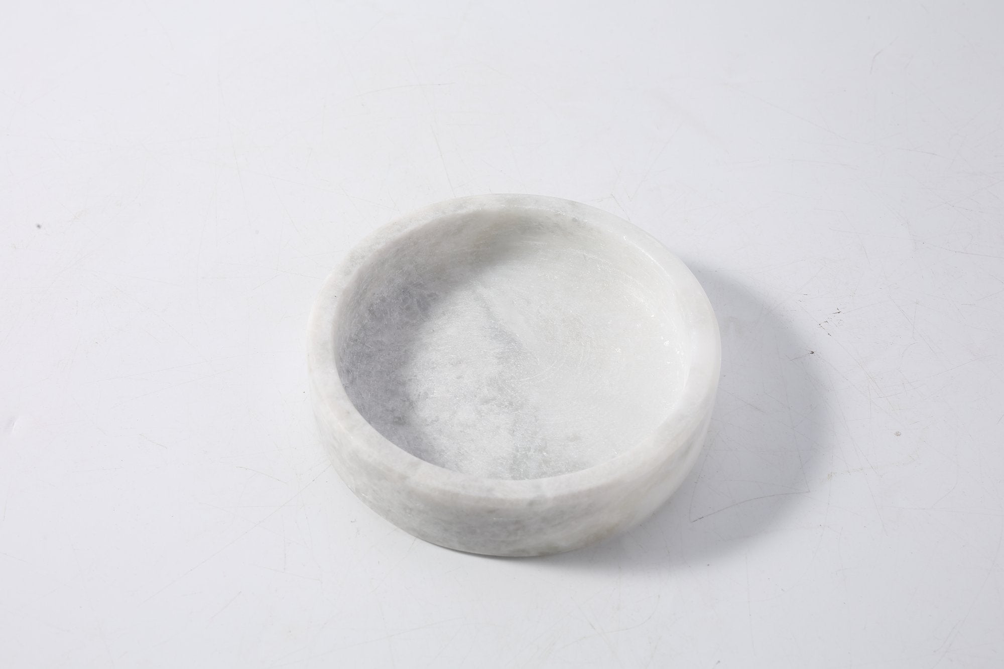 Koville Natural Stone Wine Bottle Holder in Grigio Fantasy on a dining table holding a wine bottle