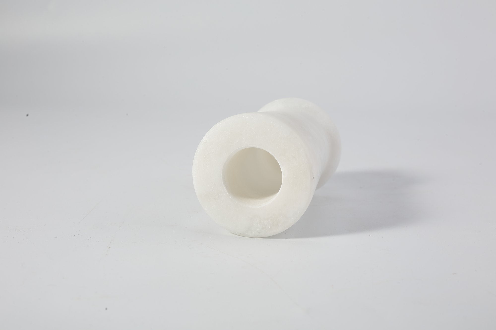 Koville natural marble orbit candle holder d 50 in Namib Bianco with a lit tea light candle