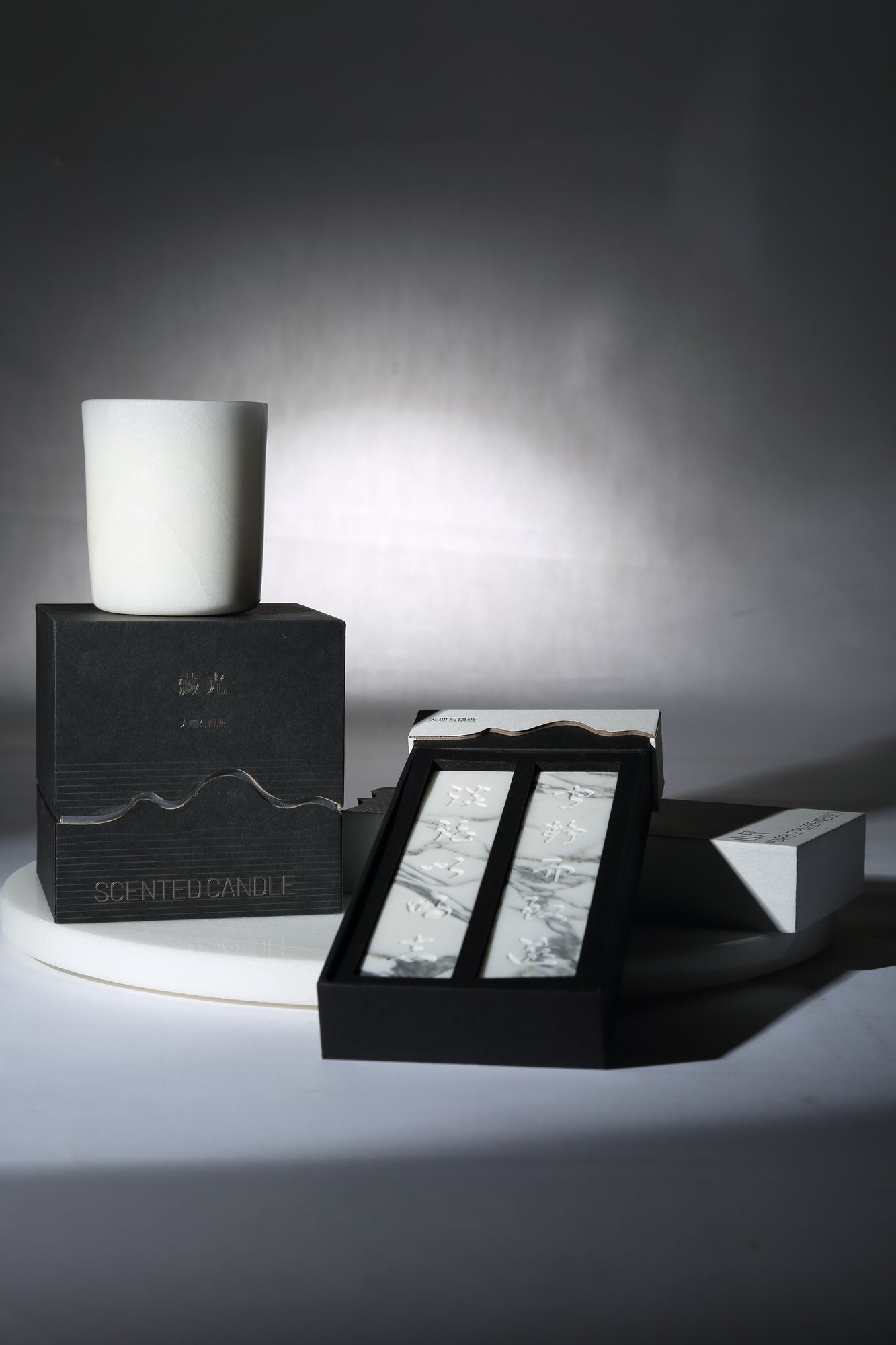 Koville natural marble scented candle d 90 in Namib Bianco with a lit tea light candle