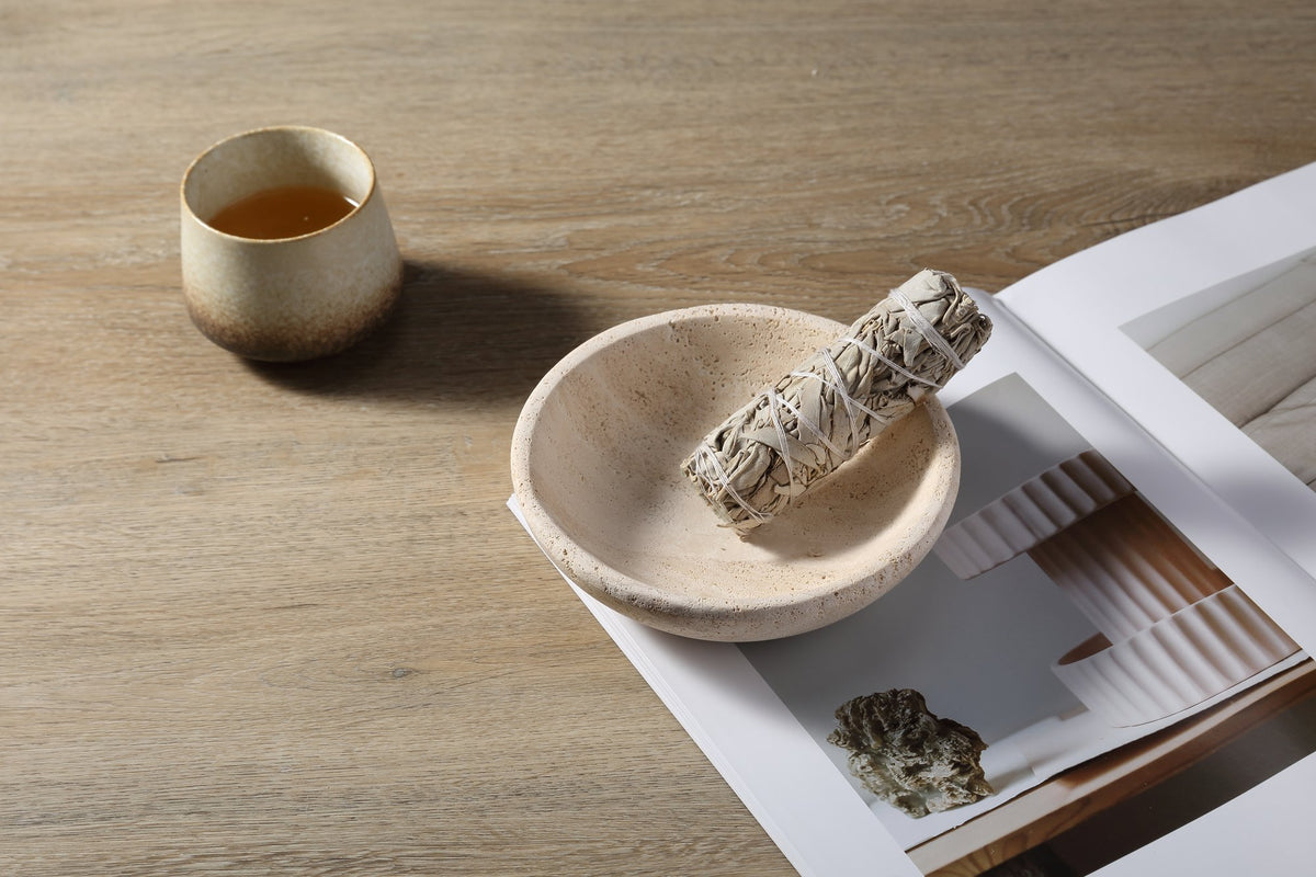 Koville Travertine incense holder arranged beside folded linen