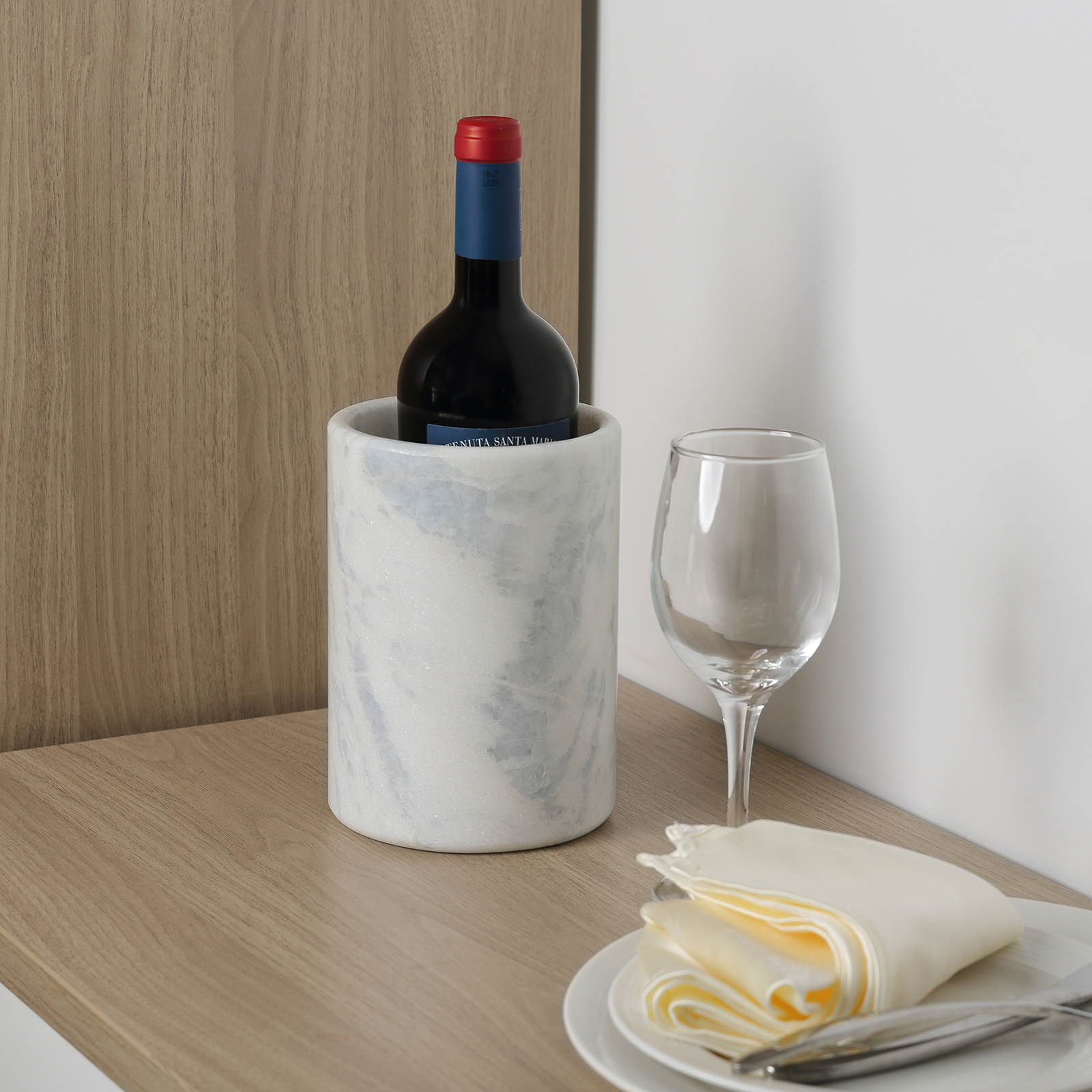 Koville Natural Stone Straight Wine Cooler in Namib Fantasy on a dining table with a wine bottle