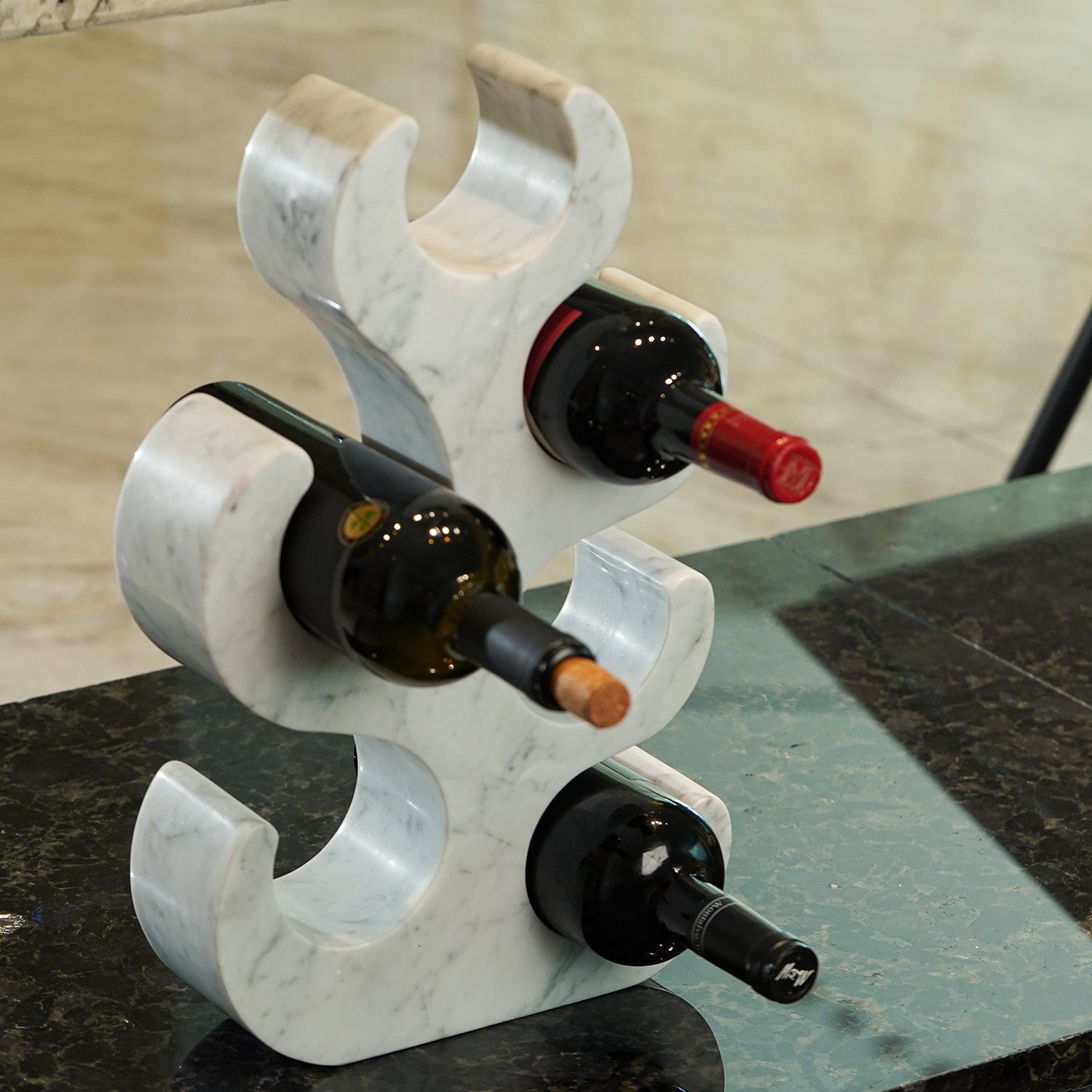 Koville Natural Stone Wine Rack in Bianco Carrara freestanding on a bar counter holding wine bottles
