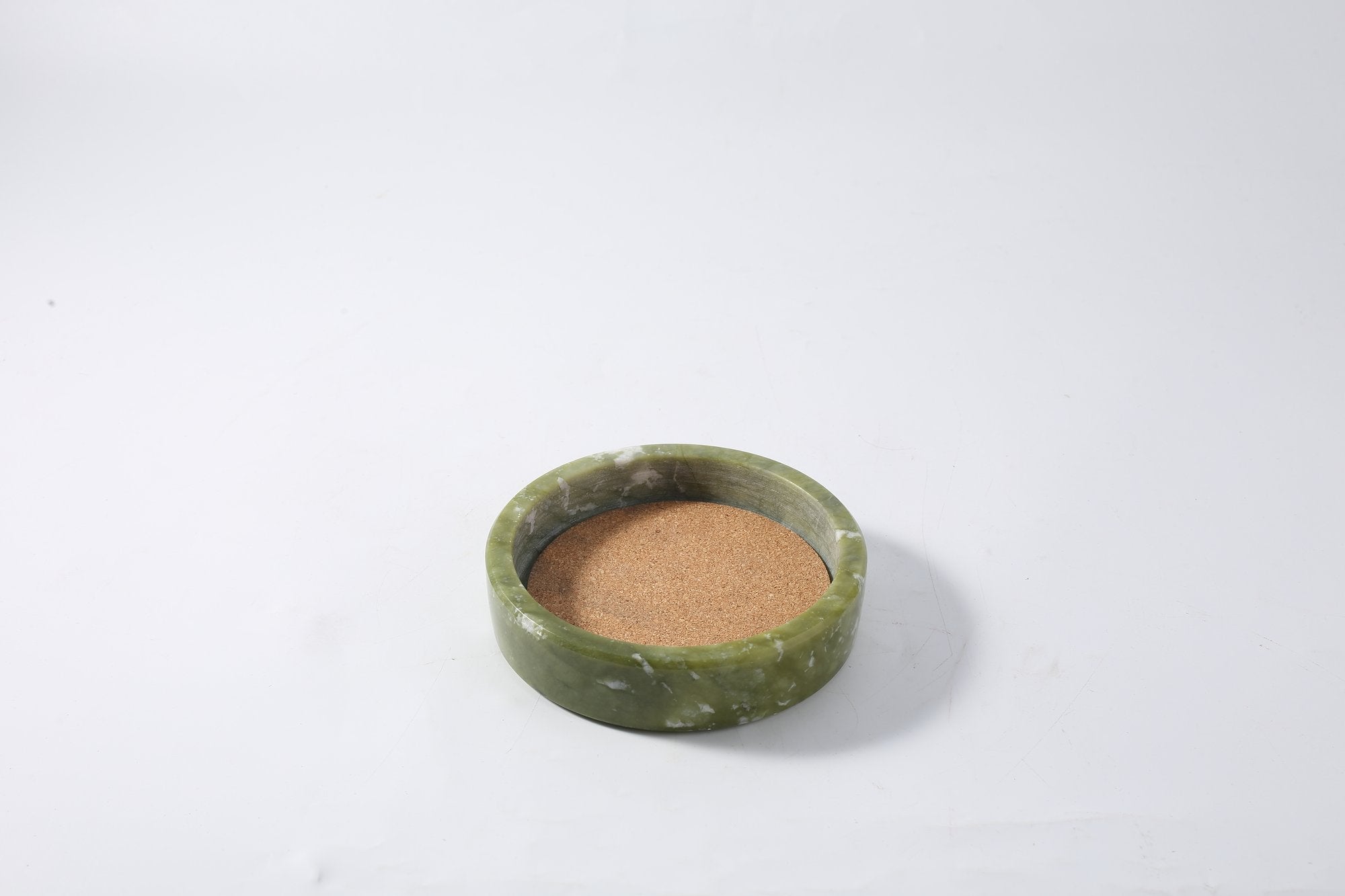 Koville Natural Stone Wine Bottle Holder in Dandong Green on a dining table holding a wine bottle