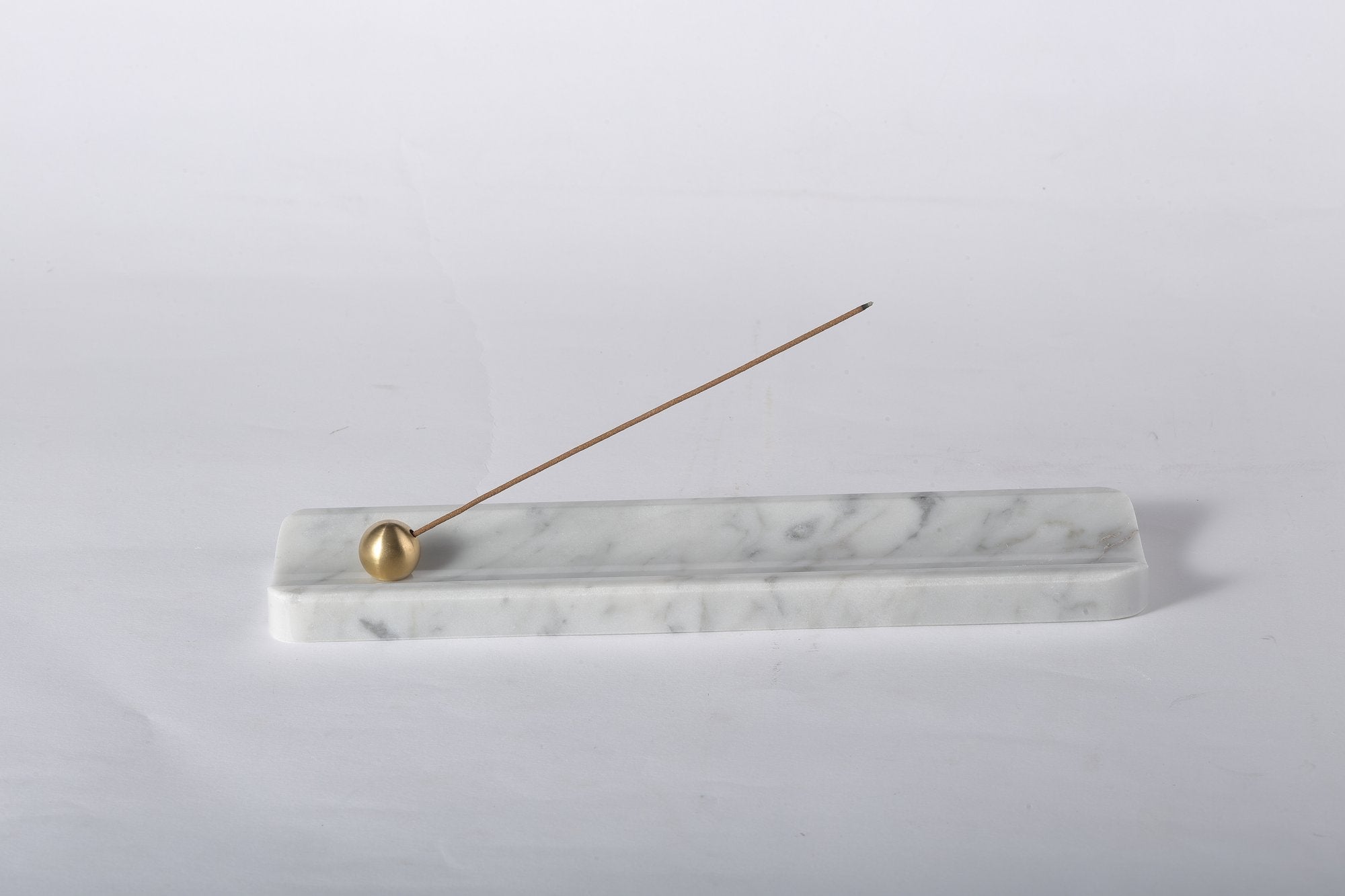 Koville natural marble incense holder in Bianco Carrara with burning incense stick