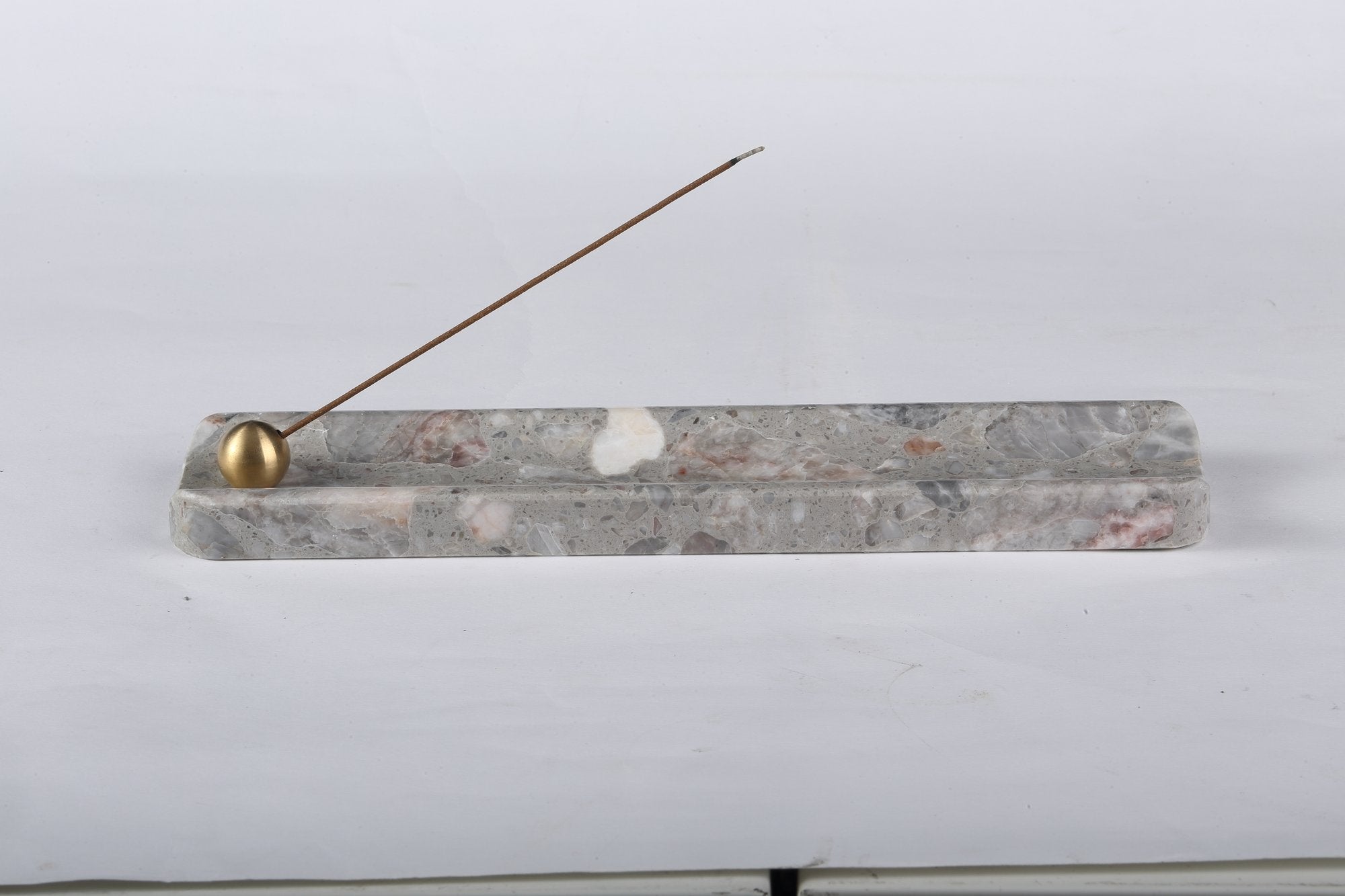 Koville natural marble incense holder in Fior di Pesco Quarella with burning incense stick