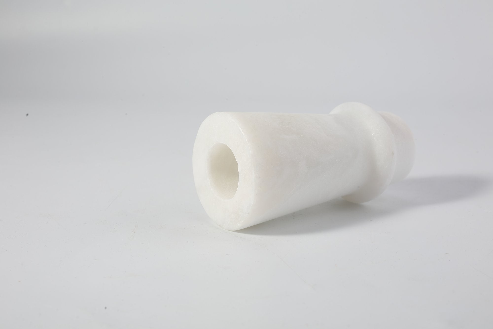 Koville natural marble orbit candle holder d 50 in Namib Bianco with a lit tea light candle
