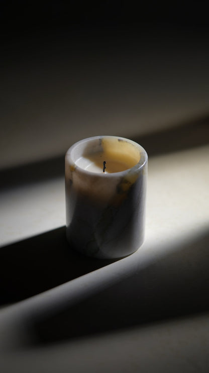 Koville natural marble scented candle d 110 in Bianco Palomino with a lit tea light candle