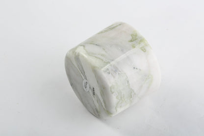 Koville natural marble scented candle d 110 in Bianco Palomino with a lit tea light candle
