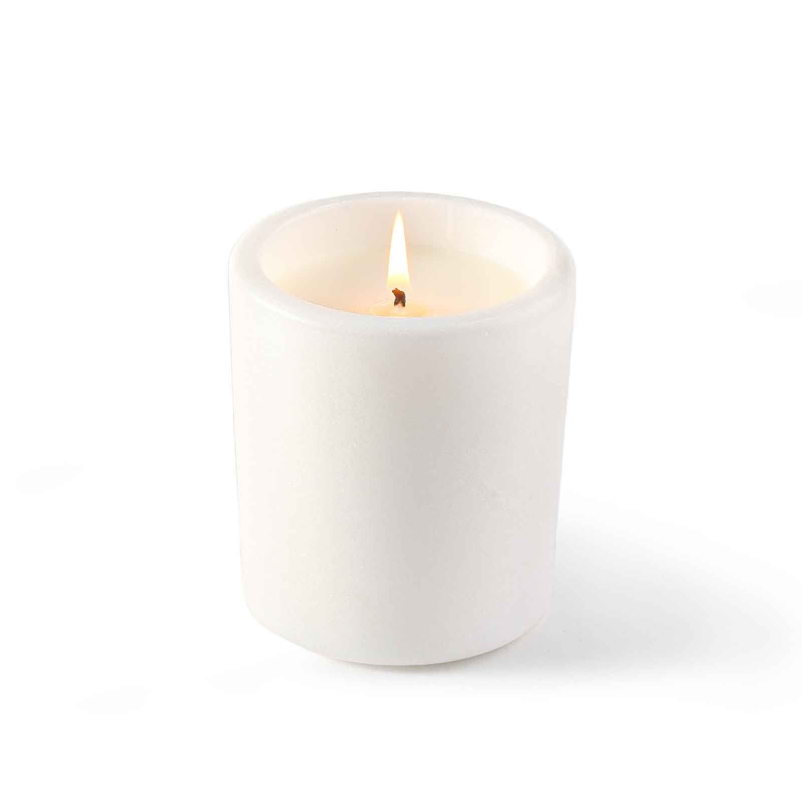 Koville natural marble scented candle d 90 in Namib Bianco with a lit tea light candle
