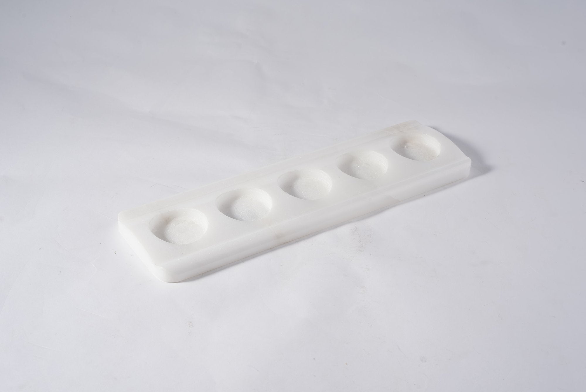 Koville natural marble tea light candle holder 5 holes in Namib Bianco with a lit tea light candle