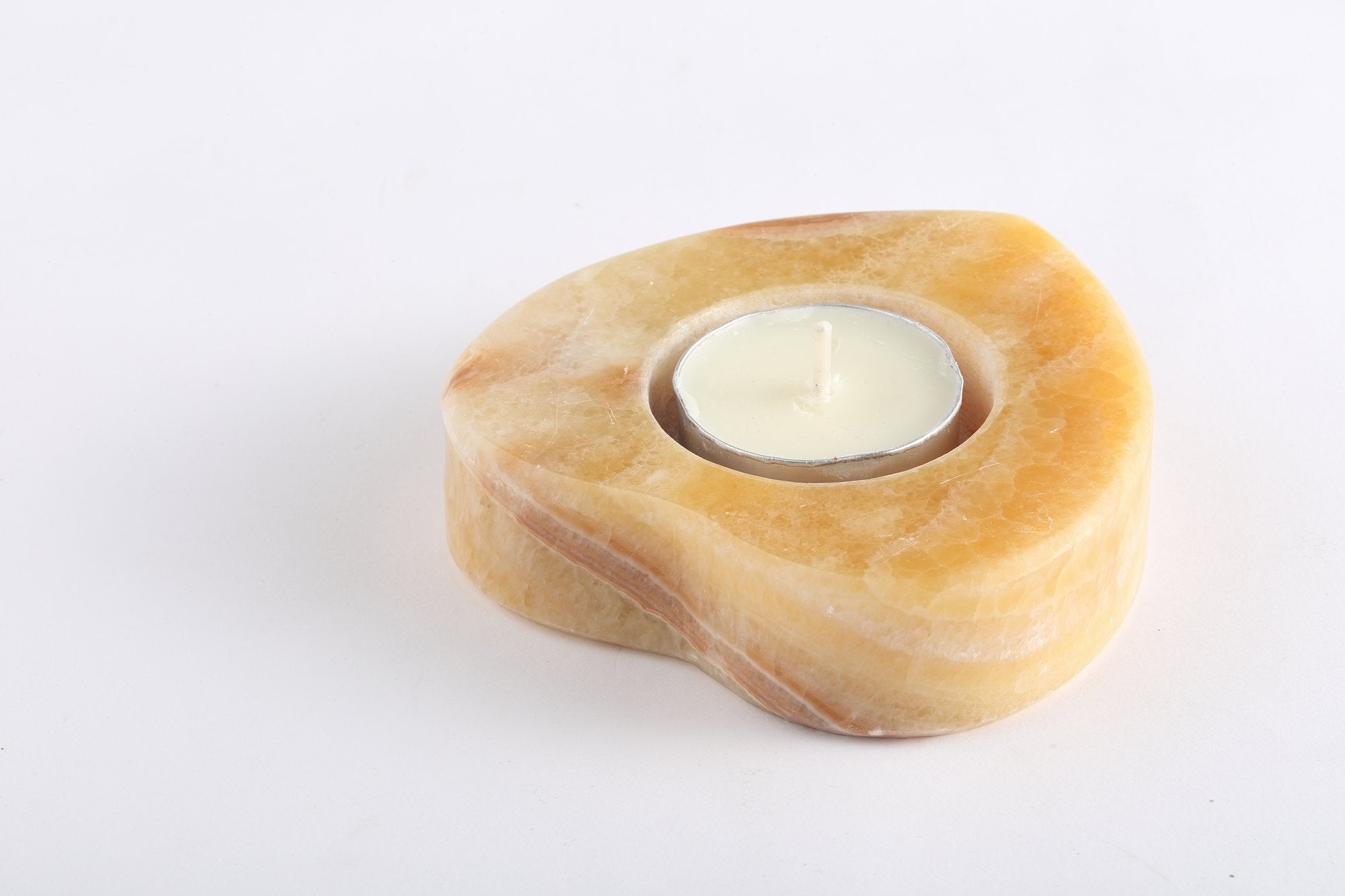 Koville natural marble tea light candle holder t 25 in Orange Onyx with a lit tea light candle